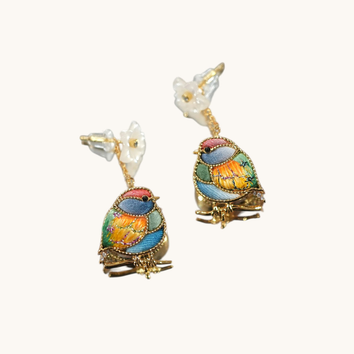 Detail view of champagne magpie Su-embroidery drop earrings